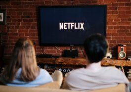 Man and Woman Sitting on a Couch in Front of a Television