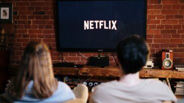 Man and Woman Sitting on a Couch in Front of a Television