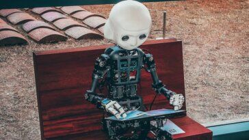 black and white robot toy on red wooden table