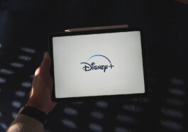 a person holding a tablet with a disney logo on it