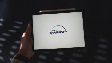 a person holding a tablet with a disney logo on it