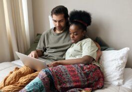 Couple With a Laptop in Bed