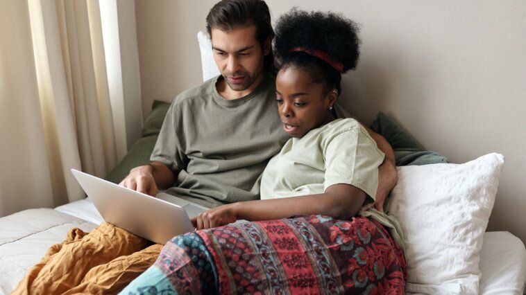 Couple With a Laptop in Bed